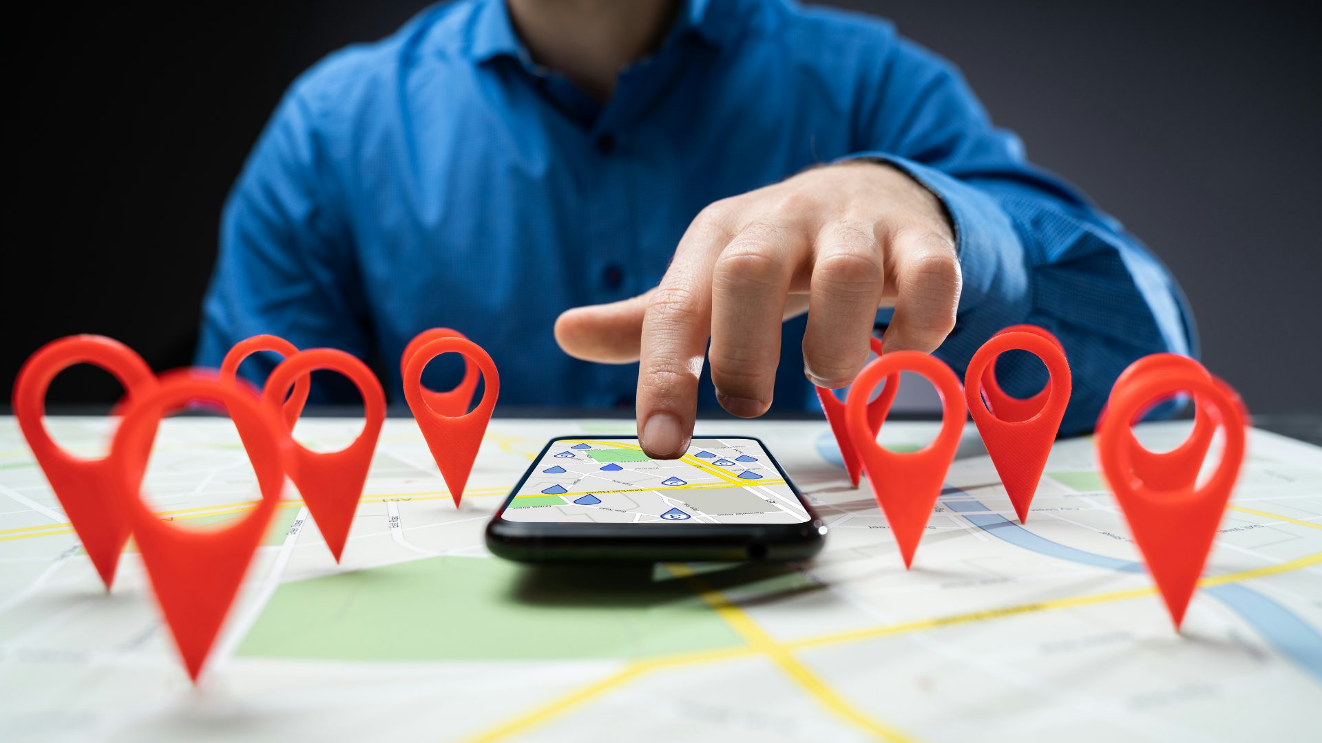Person touching phone with map location pins